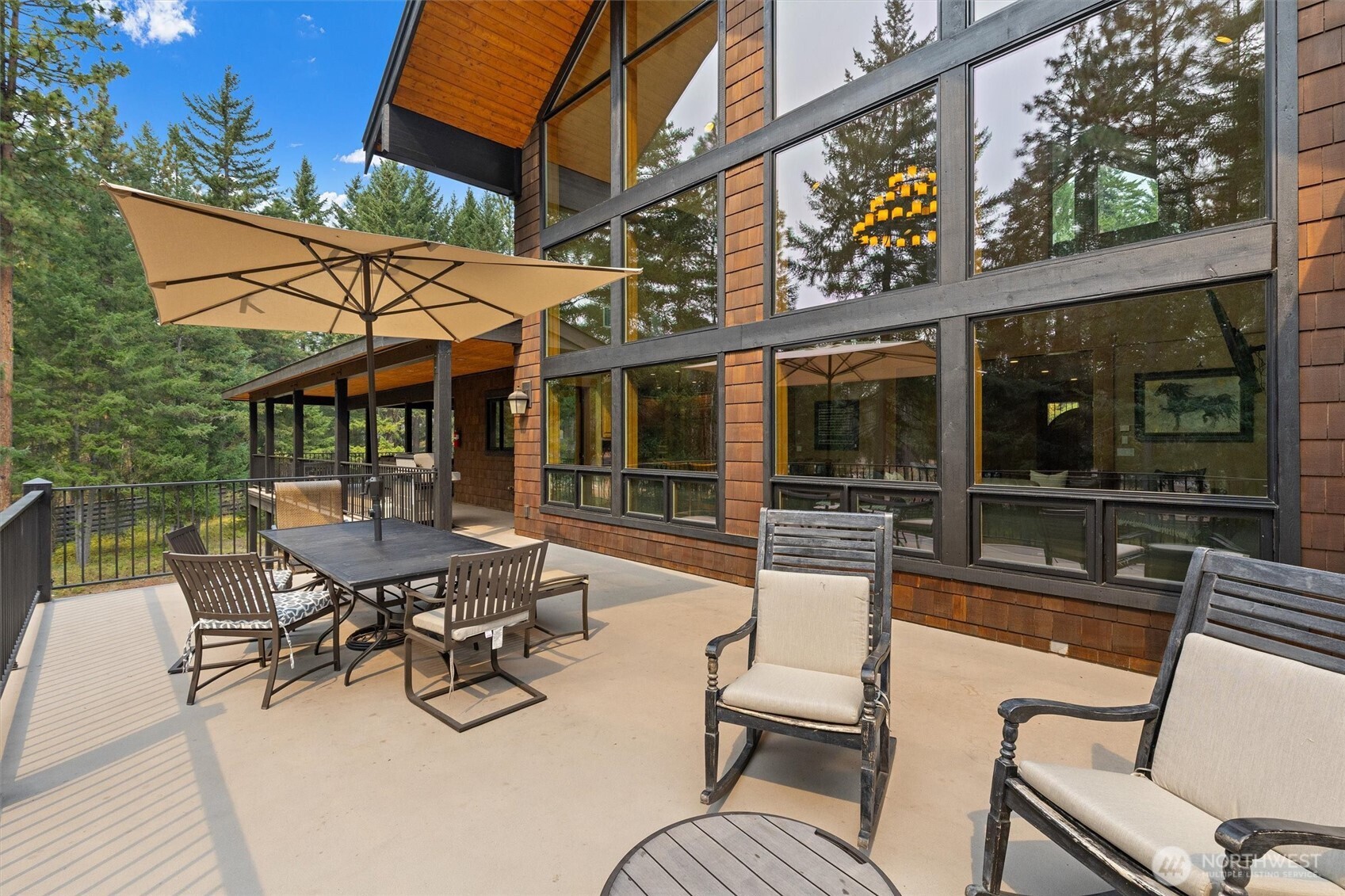 251 Evergreen Valley Loop Road Ronald, WA 98940 - Photo 15 of 40 a view of a patio with table and chairs potted plants with wooden floor and fence