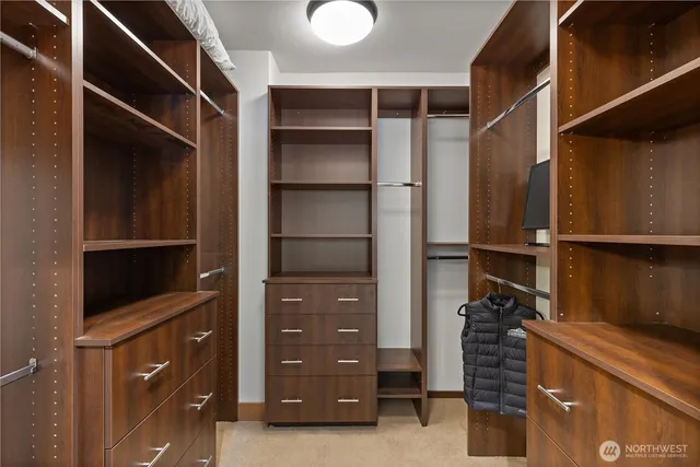 a view of walk in closet with clothes and shoes