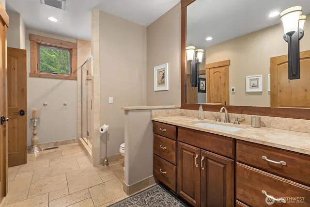 a spacious bathroom with a granite countertop sink a mirror and a