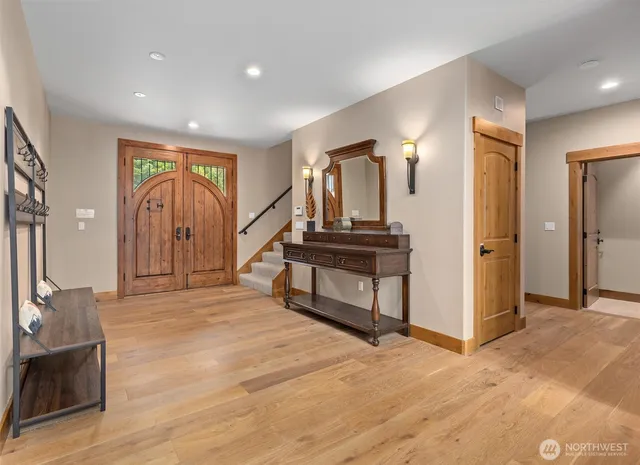 a view of a hallway with wooden floor and staircase