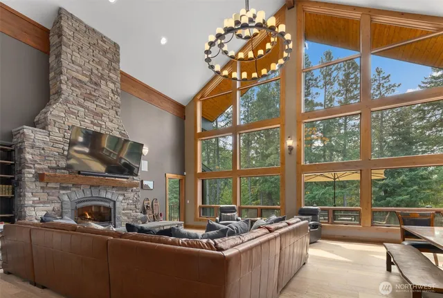 a living room with fireplace furniture and a large window