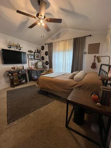 a bedroom with a bed and ceiling fan
