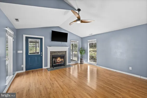 a kitchen with stainless steel appliances a sink dishwasher a stove top oven a refrigerator with white cabinets and wooden floor