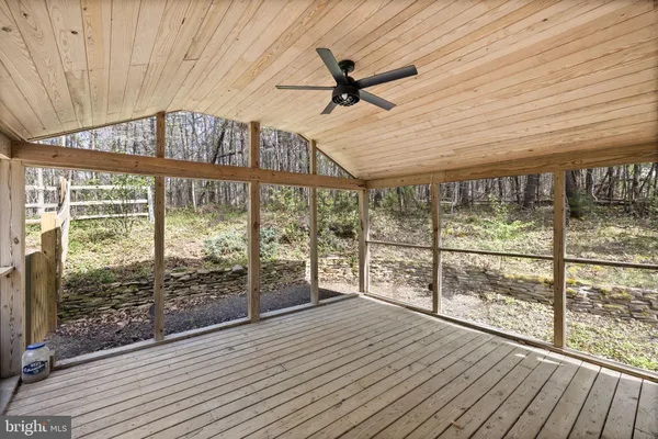 a view of a patio with a table chairs and wooden floor