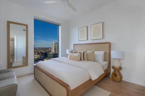 a bedroom with a bed and a potted plant on dresser