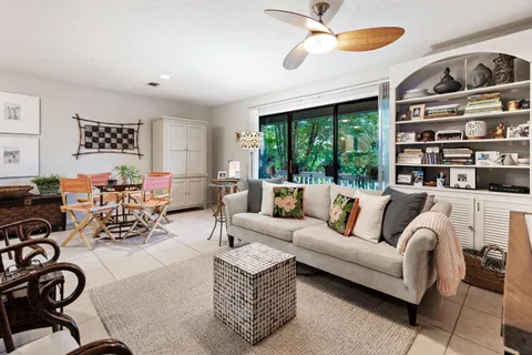 a living room with furniture a flat screen tv and a large window