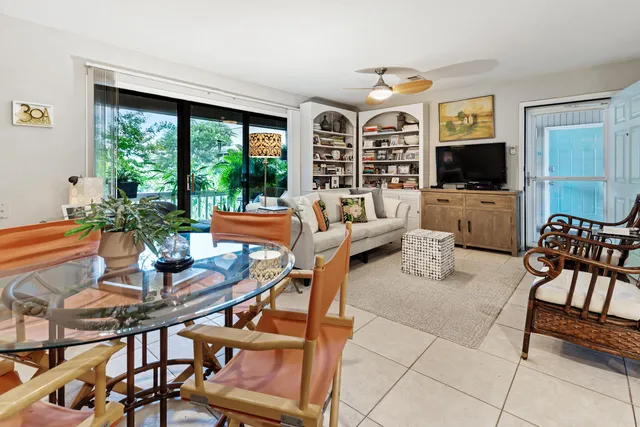 a living room with furniture a flat screen tv and a large window