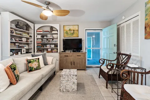 a living room with furniture a flat screen tv and kitchen view