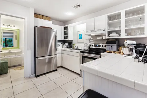a kitchen with stainless steel appliances a refrigerator sink and cabinets