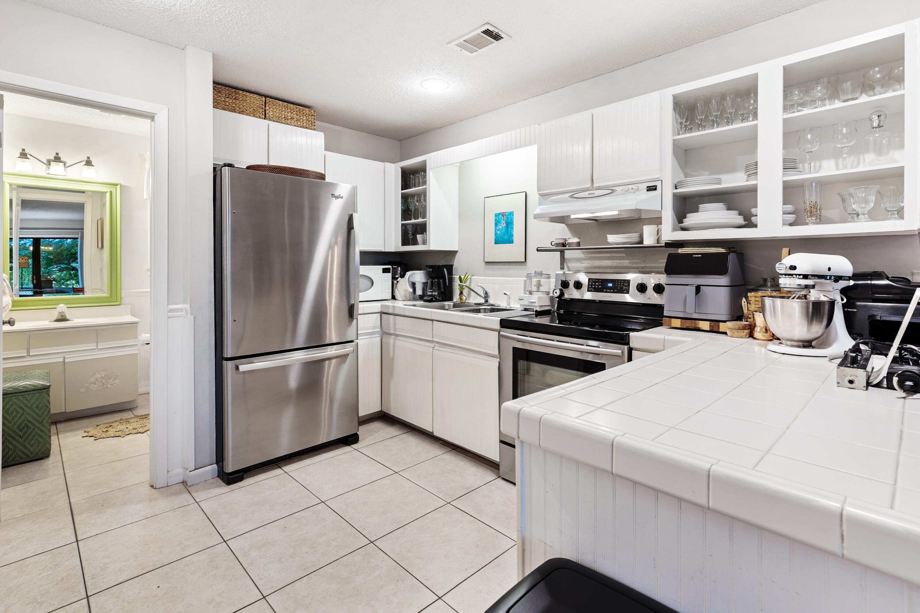 3799 East County Highway 30A, Unit D5 Santa Rosa Beach, FL 32459 - Photo 5 of 34 a kitchen with stainless steel appliances a refrigerator sink and cabinets