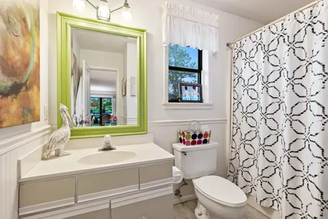 a bathroom with a sink a toilet and a mirror