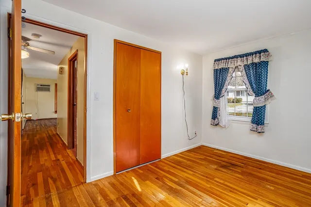 a view of a bedroom with wooden floor and bathroom