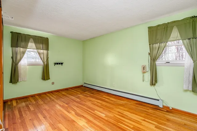 a view of a room with wooden floor and windows