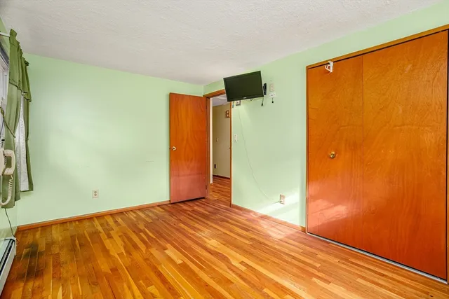 a view of a room with wooden floor and a window