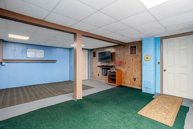 a view of an empty room with kitchen and a window