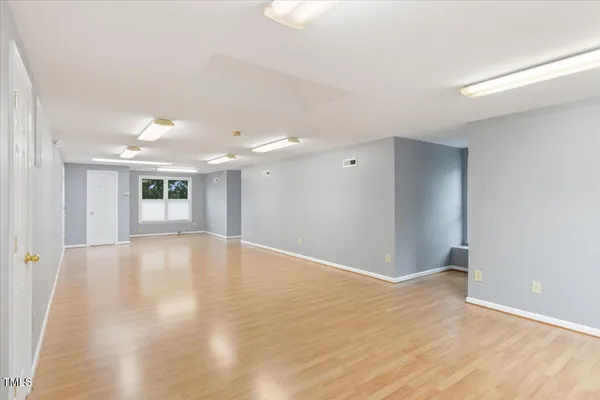 a view of empty room with wooden floor