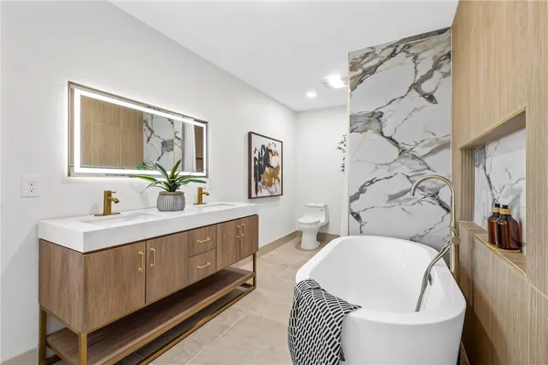 a spacious bathroom with a toilet a sink and a mirror