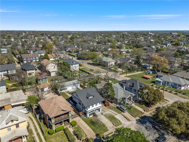 an aerial view of residential houses with city view