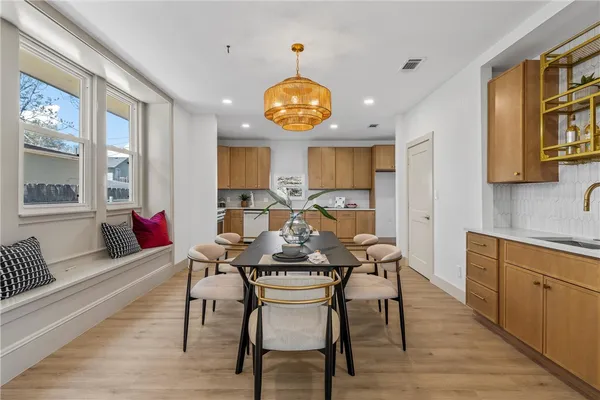 a view of a dining room with furniture a chandelier and wooden floor