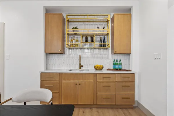 a living room with stainless steel appliances kitchen island granite countertop a sink and a cabinets