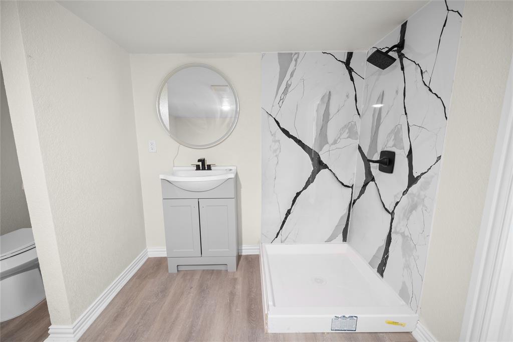 823 Clark Street Tyler, TX 75701 - Photo 15 of 17 a bathroom with a sink a mirror and a shower