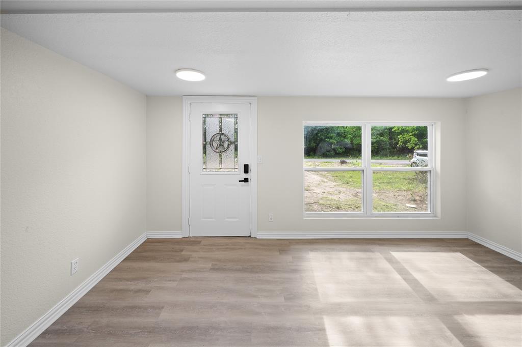 823 Clark Street Tyler, TX 75701 - Photo 4 of 17 an empty room with wooden floor and a window
