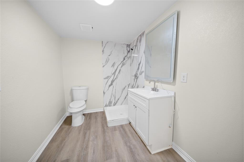823 Clark Street Tyler, TX 75701 - Photo 9 of 17 a bathroom with a sink a toilet and a mirror