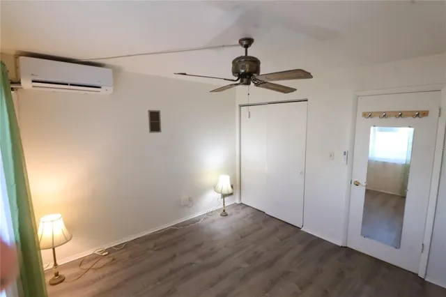 a view of empty room with wooden floor and fan