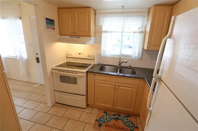 a kitchen with a stove a sink and a window