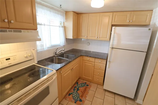 a kitchen with a refrigerator a sink and a window