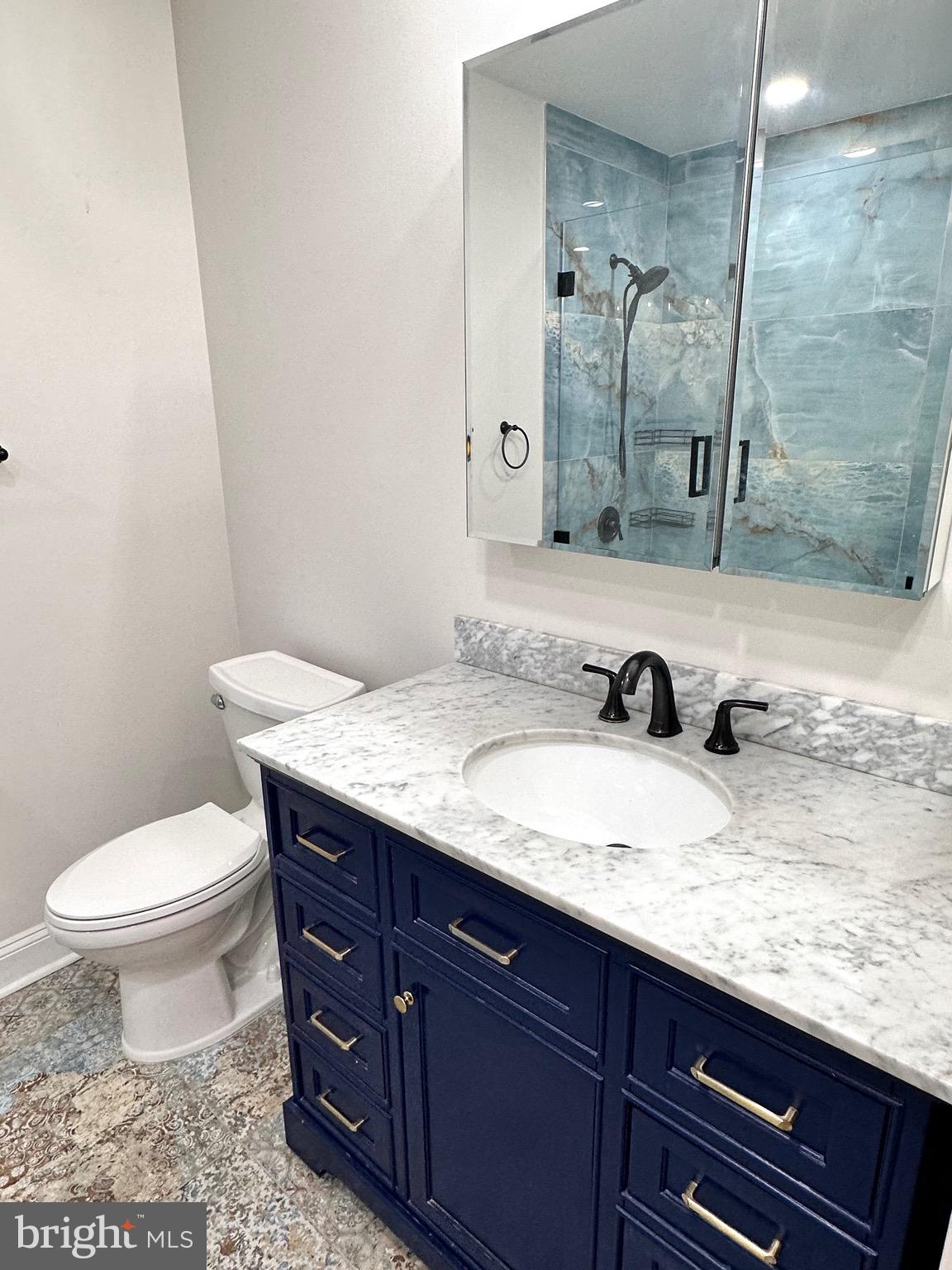 1201 North Garfield Street, Unit 408 Arlington, VA 22201 - Photo 9 of 26 a bathroom with a granite countertop sink a toilet and a mirror