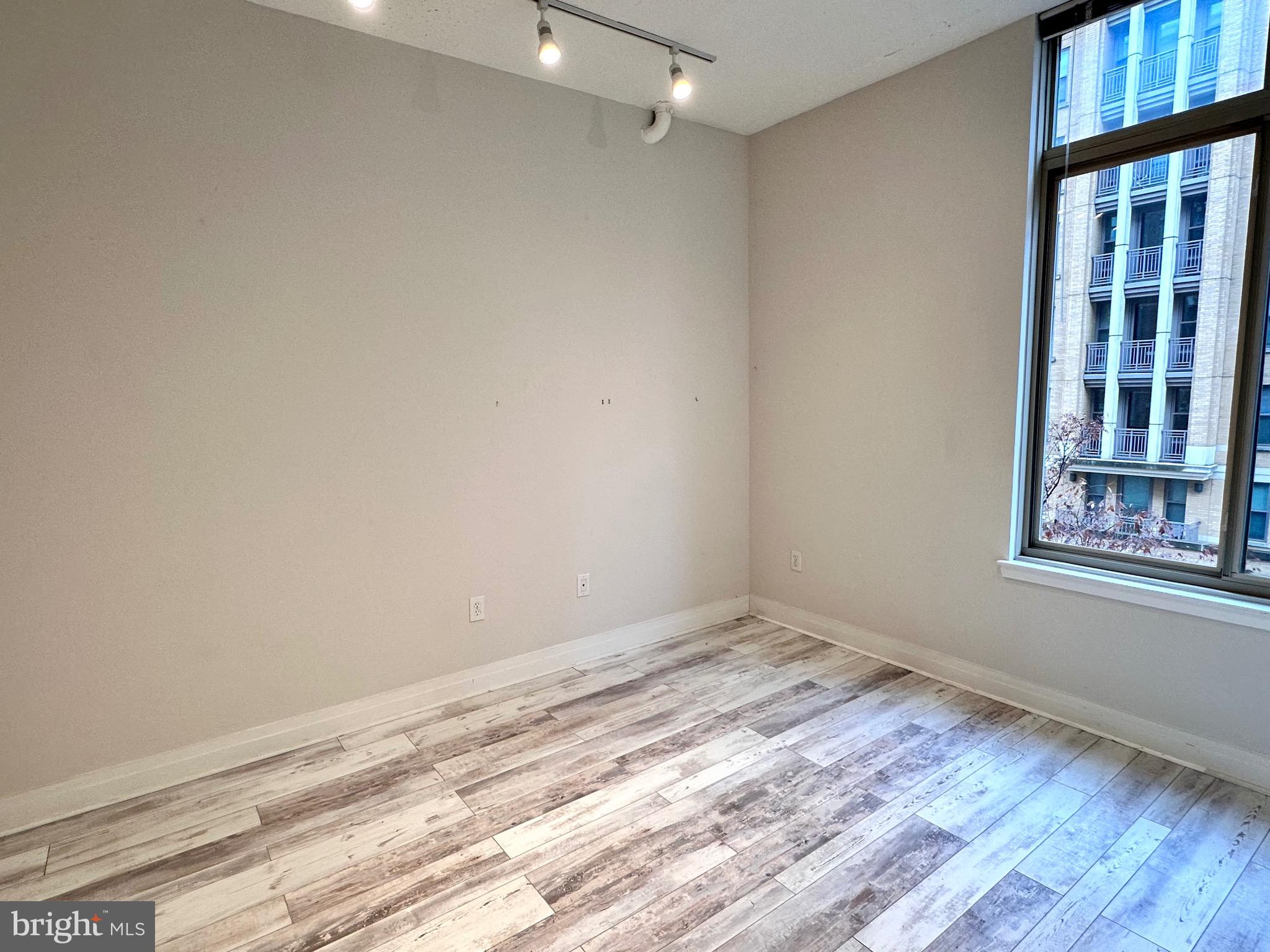 1201 North Garfield Street, Unit 408 Arlington, VA 22201 - Photo 13 of 26 an empty room with wooden floor and windows
