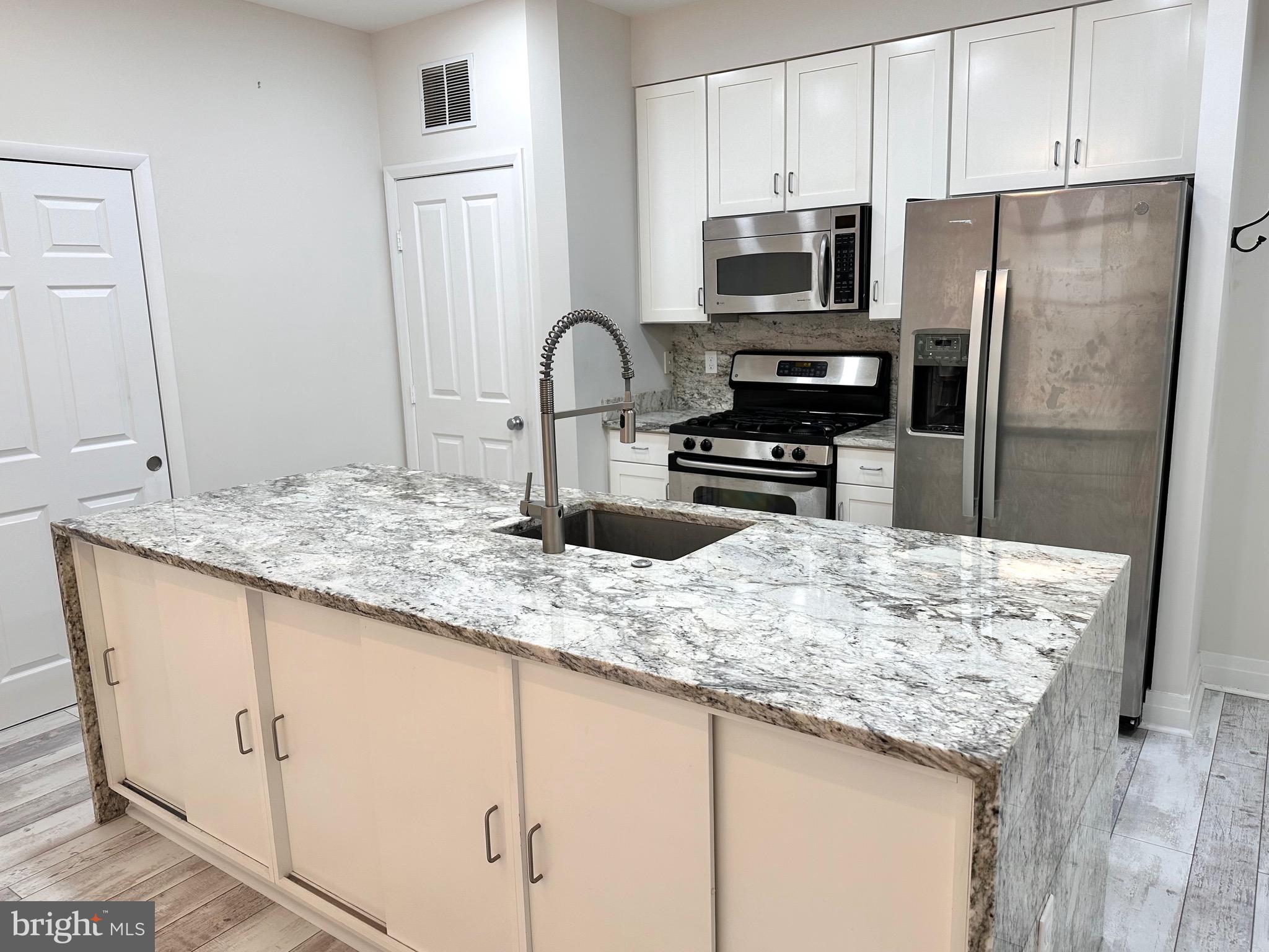 1201 North Garfield Street, Unit 408 Arlington, VA 22201 - Photo 3 of 26 a kitchen with granite countertop a refrigerator and a stove top oven