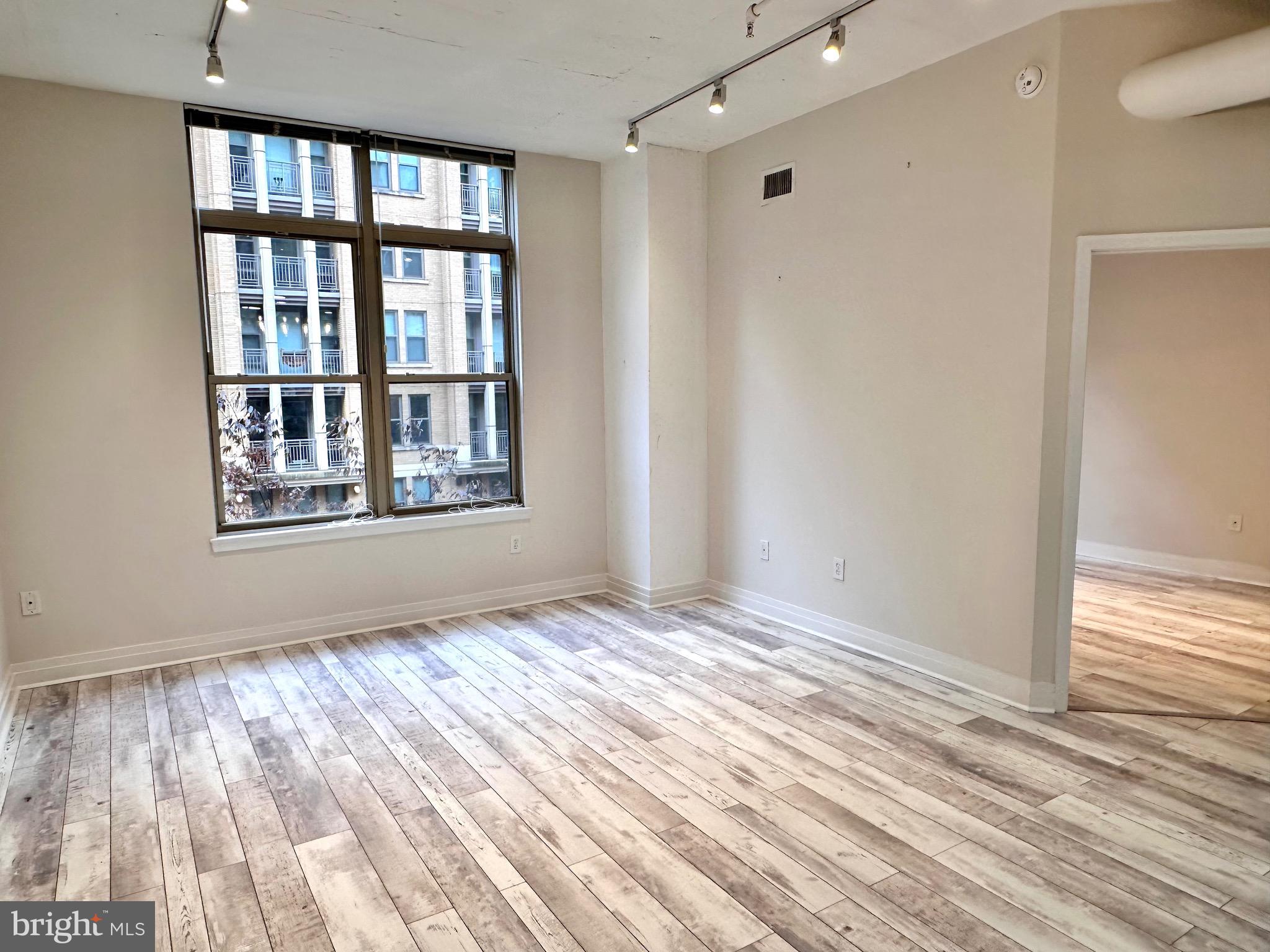 1201 North Garfield Street, Unit 408 Arlington, VA 22201 - Photo 5 of 26 a view of an empty room with wooden floor and a window