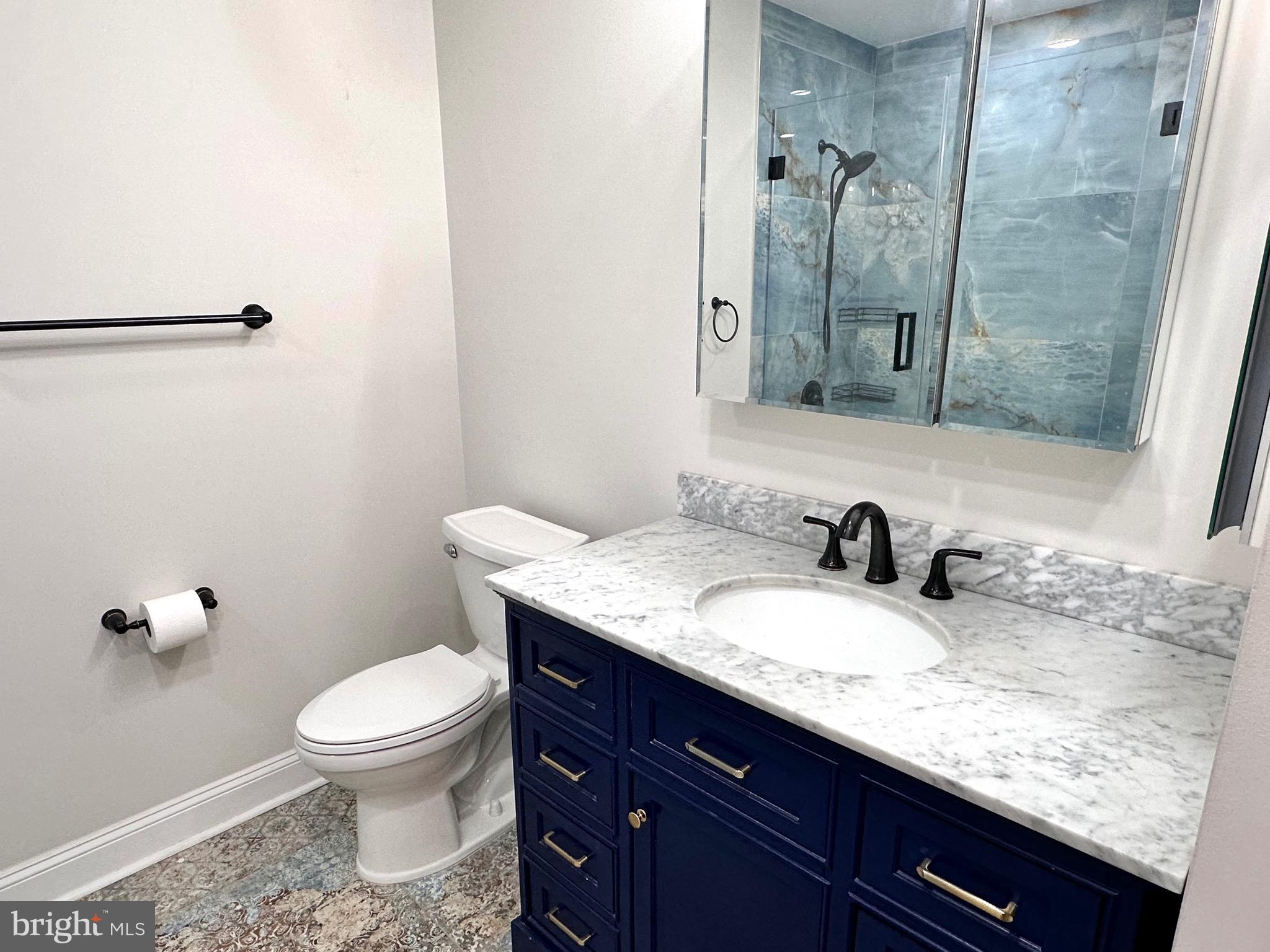 1201 North Garfield Street, Unit 408 Arlington, VA 22201 - Photo 8 of 26 a bathroom with a granite countertop sink a toilet and a mirror