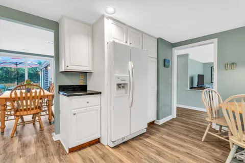 a bedroom with a bed a dresser and potted plants