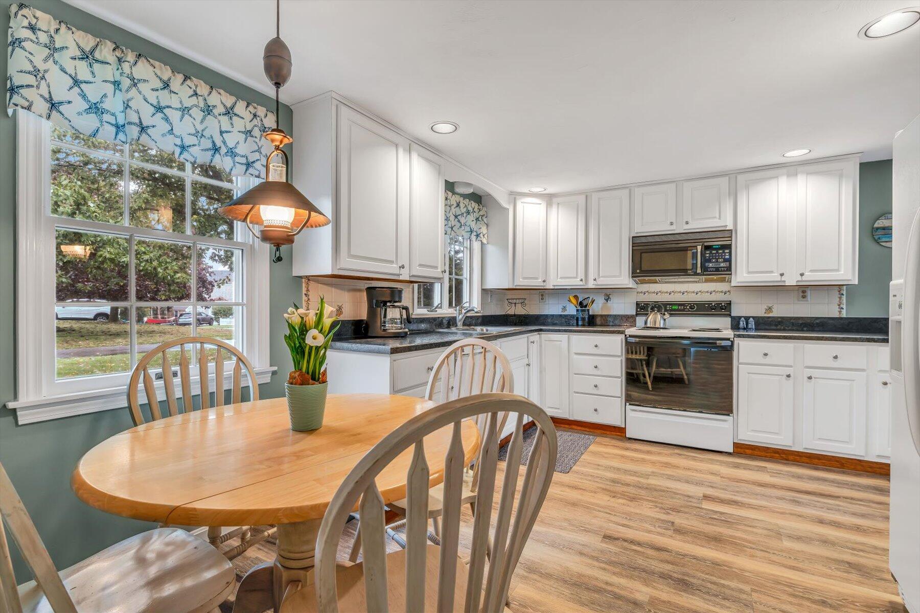 30 Cove Road Eastham, MA 02642 - Photo 36 of 72 a kitchen with stainless steel appliances granite countertop a stove a sink a microwave a dining table and chairs