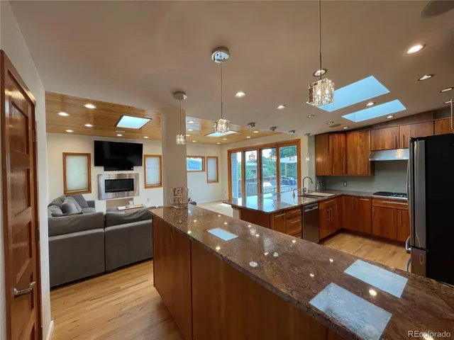 a large kitchen with stainless steel appliances a large counter top a stove and a sink