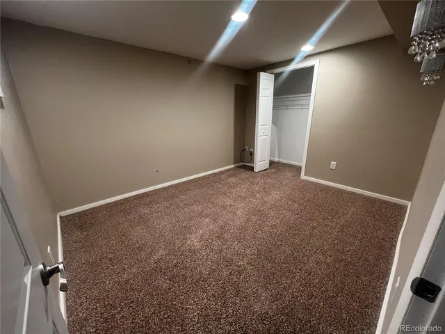 a view of an empty room with a cabinet and a refrigerator