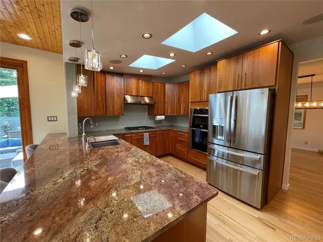 a kitchen with stainless steel appliances a refrigerator sink and cabinets