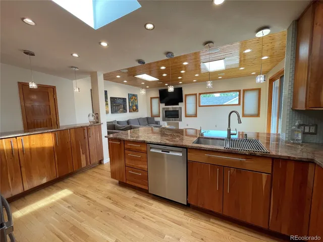 a kitchen with stainless steel appliances wooden cabinets a stove top oven a sink and dishwasher