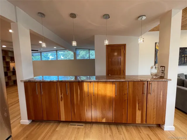 a kitchen with stainless steel appliances kitchen island granite countertop a table chairs and a refrigerator