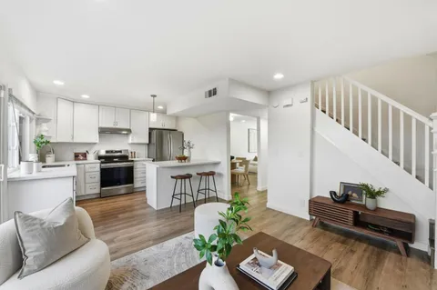 a living room with furniture and a wooden floor