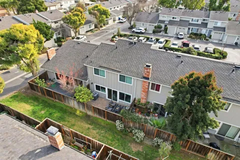 an aerial view of residential houses with outdoor space and trees