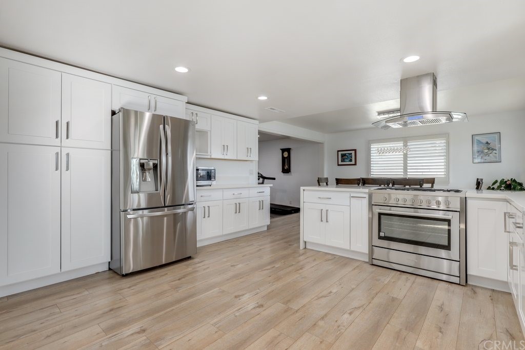 13772 Ridgecrest Circle Tustin, CA 92780 - Photo 4 of 69 a kitchen with white cabinets and stainless steel appliances
