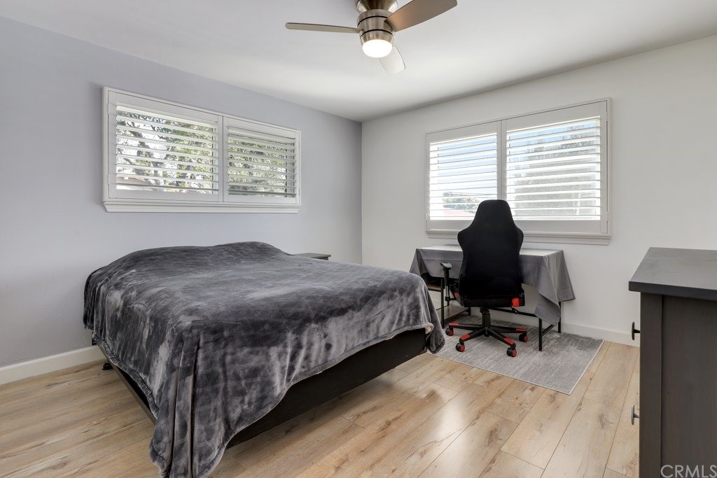 13772 Ridgecrest Circle Tustin, CA 92780 - Photo 42 of 69 a bedroom with a bed a desk and chair with wooden floor