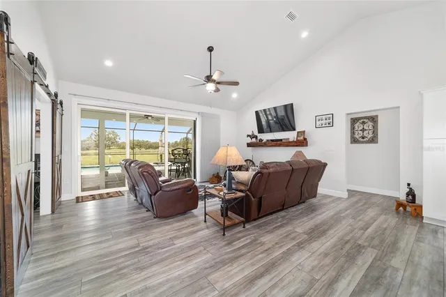a kitchen with stainless steel appliances kitchen island granite countertop a table chairs stove and white cabinets