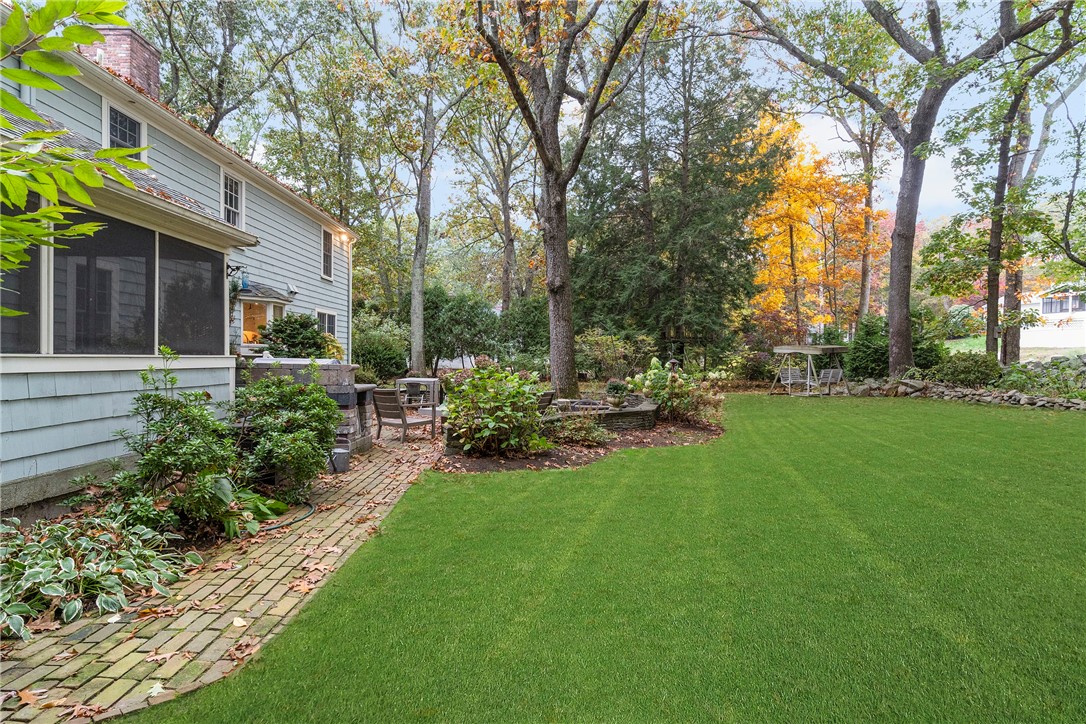 99 Larch Road East Greenwich, RI 02818 - Photo 32 of 38 Side view of yard. Sun porch on the left and a brick walkway leading to outdoor kitchen and brick patio