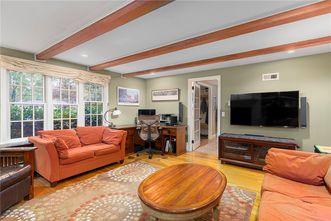 99 Larch Road East Greenwich, RI 02818 - Photo 6 of 38 Family room with gorgeous wood beams. The triple width window brings in light and the mature landscaping allows for privacy.
