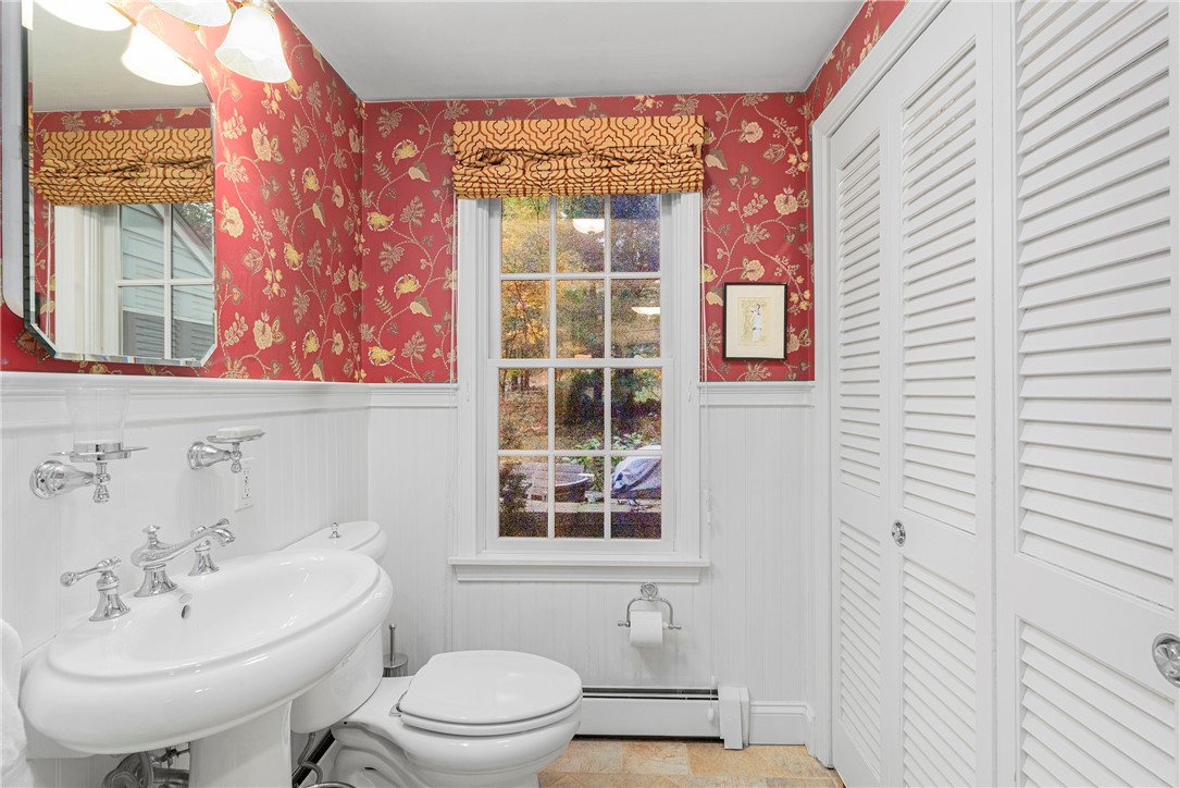 99 Larch Road East Greenwich, RI 02818 - Photo 9 of 38 Powder room off hallway between family room and kitchen. The wainscoting add a special design and behind the doors is the laundry area.